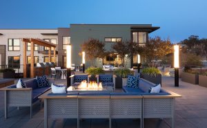 Image 56 - Oakland, CA, Luxury Apartments - Baxter on Broadway - Rooftop Deck with Gas Grills, Outdoor Seating, Fire Pits, Elevated Planters, and Modern Light Fixtures.